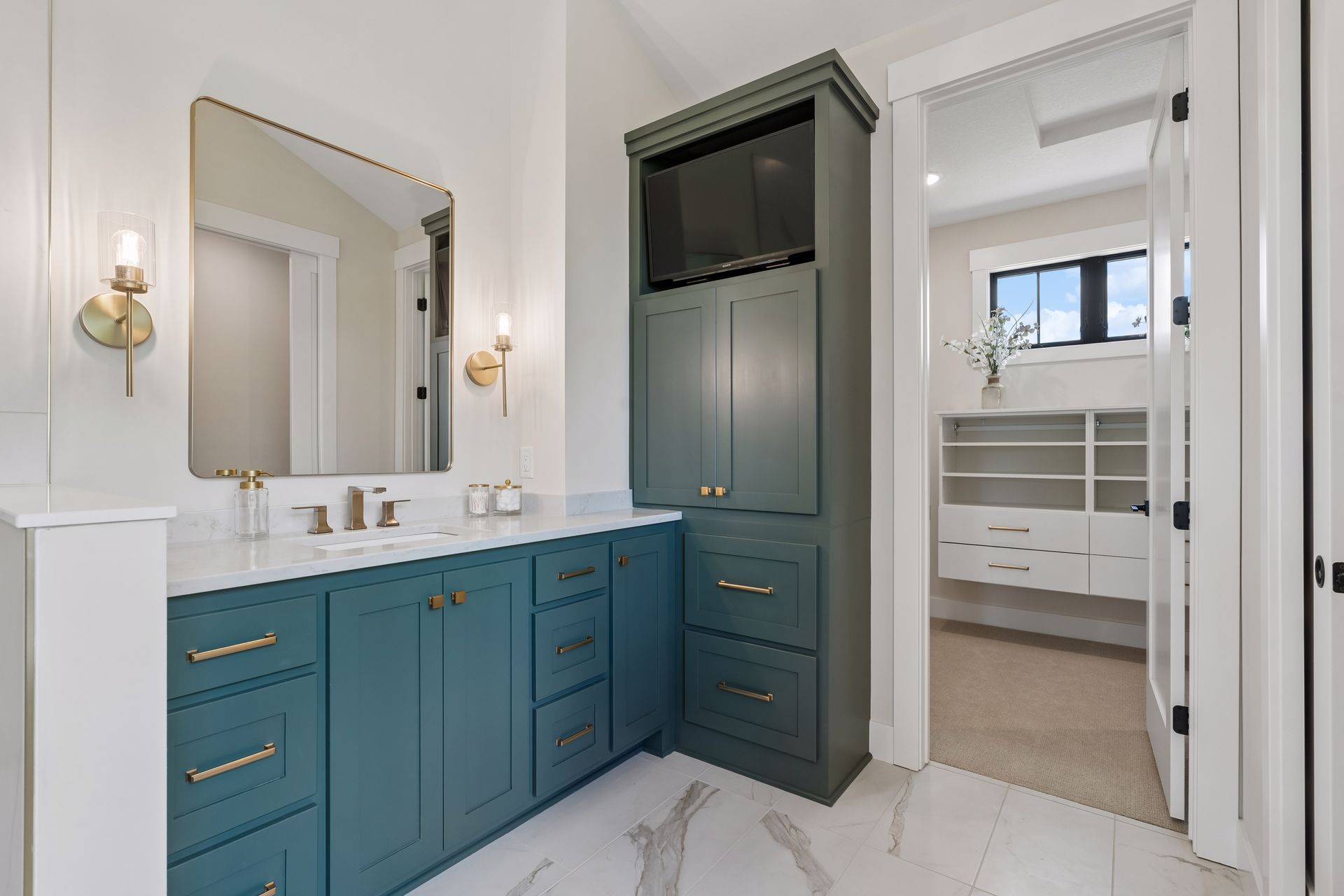 Luxury primary bathroom vanity with custom cabinetry, quartz countertops and designer fixtures